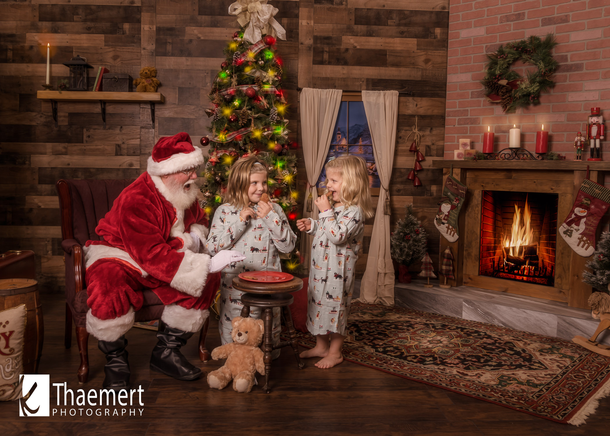 Photo of Santa and Two little girl having Cookies at their photo shoot