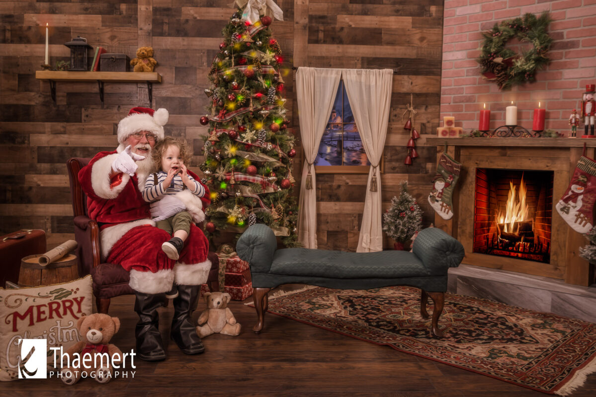 Curly Haired Toddler Boy Sits with Santa Claus